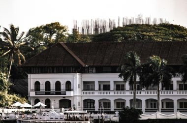 Elegant hotel exterior with palm trees and water, perfect for travel inspiration.